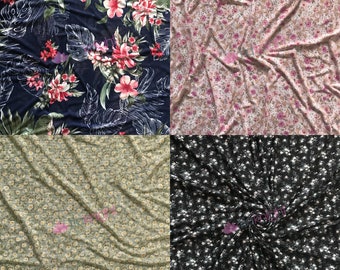 May include: Four different fabric swatches with floral patterns. The swatches are arranged in a grid, with a blue floral pattern in the top left, a pink floral pattern in the top right, a green floral pattern in the bottom left, and a black floral pattern in the bottom right.