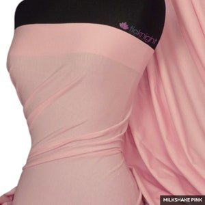Puede incluir: Una tela rosa claro drapeada sobre un maniqu&iacute;. La tela es suave y fluida, con las palabras "Milkshake Pink" en un recuadro blanco en la parte inferior derecha. La marca "tiaknight" es visible en la esquina superior derecha.