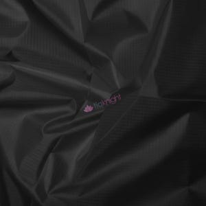 May include: Close-up of black fabric with a subtle grid pattern. The material is draped, creating folds and shadows that add depth. The fabric has a slight sheen, suggesting a smooth texture. The logo "tiaknight" is visible in the corner.