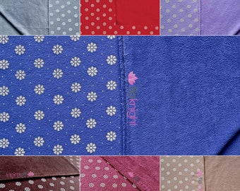 May include: A set of ten fleece blankets with snowflake patterns in various colors, including blue, red, purple, brown, pink, and beige. The blankets are all the same size and have a soft, fuzzy texture.