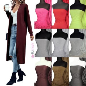 Può includere: Una collezione di dieci campioni di tessuto in vari colori, tra cui rosa, rosso, verde, grigio, marrone e nero. Il tessuto è liscio e ha una leggera lucentezza. I campioni sono esposti su manichini.