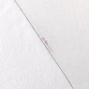 May include: A close-up of two white fabric samples. One side is a textured, terry cloth material, and the other is a smooth, woven fabric. The brand name "tiaknight" is printed in pink on the woven fabric.