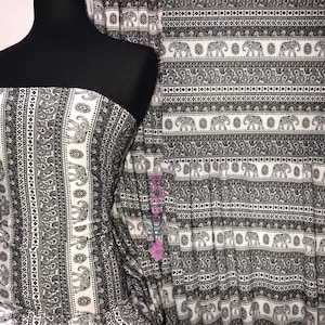 May include: Black and white fabric with a repeating pattern of elephants and paisley designs. The fabric is striped with alternating black and white bands.