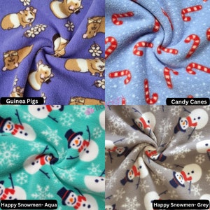 May include: Four different fleece fabric swatches with various patterns. The top left swatch is purple with a white and brown guinea pig pattern. The top right swatch is light blue with a red and white candy cane pattern. The bottom left swatch is teal with a white snowman pattern. The bottom right swatch is grey with a white snowman pattern.