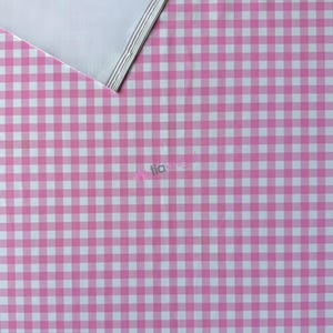 K&ouml;nnte beinhalten: Ein Stoff mit einem sich wiederholenden rosa-wei&szlig;en Vichy-Karomuster. Eine Ecke des Materials ist umgeschlagen und gibt den Blick auf eine einfarbig wei&szlig;e Unterseite frei. Der Text tia knight ist in kleiner, hellrosa Schrift mittig aufgedruckt.