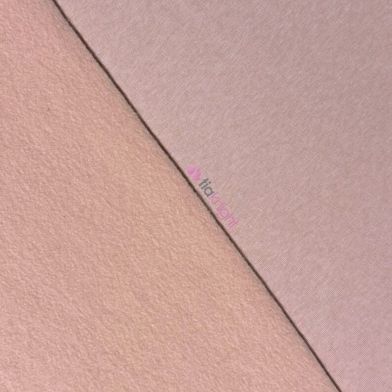 May include: A diagonal split image showcasing two different textures of fabric. The top right section displays a smooth, solid, light mauve fabric, while the bottom left reveals a textured, peach-colored fabric. The fabrics are separated by a dark line.