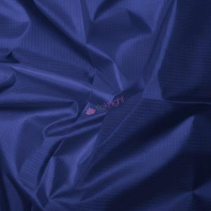 May include: Close-up of a deep blue fabric with a subtle grid pattern. The material has a slight sheen, with visible folds and creases adding texture. The fabric appears to be lightweight and possibly suitable for apparel or craft projects.