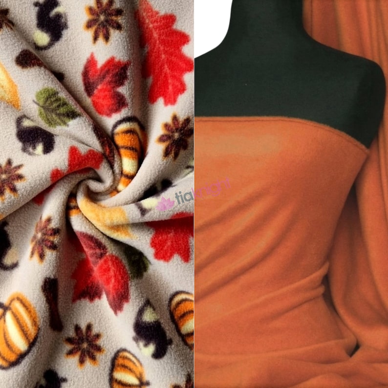 May include: Two pieces of fleece fabric. One is beige with a pattern of pumpkins, leaves, and acorns. The other is a solid orange.