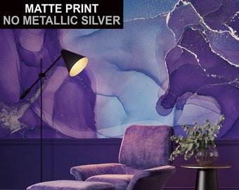 May include: A purple velvet armchair with a matching ottoman, a black floor lamp, and a small black side table with a vase of eucalyptus leaves. The background is a purple and blue abstract watercolor print with the text "MATTE PRINT NO METALLIC SILVER".
