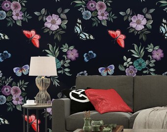 May include: A dark blue wallpaper with a floral pattern featuring pink, purple, and green flowers and red butterflies. The wallpaper is shown in a living room setting with a gray sofa, two lamps, and a coffee table.