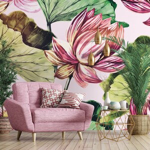 Pu&ograve; includere: Una poltrona rosa con gambe in legno e due cuscini decorativi &egrave; posta di fronte a una carta da parati floreale con grandi fiori rosa e verdi. Un tavolino dorato e lampade a sospensione completano l'arredamento.