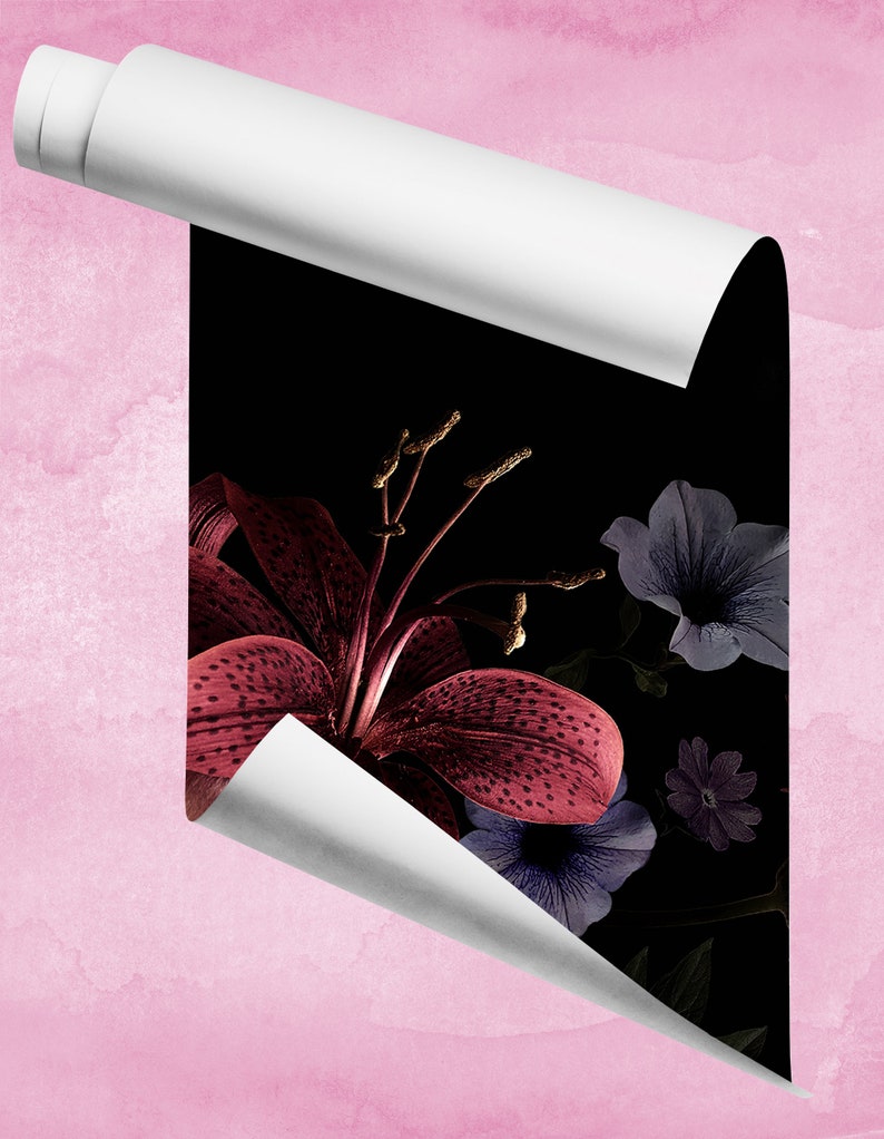 May include: A close-up of a dark red lily with white spots, surrounded by purple and blue flowers on a black background. The image is partially obscured by a white sheet of paper.