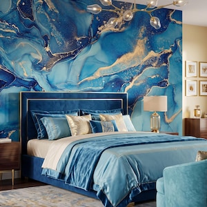 May include: A bedroom featuring a blue velvet bed frame with gold trim, layered with blue and gold bedding. The wall behind the bed displays a large-scale blue and gold marble-patterned mural. A gold chandelier with glass globes hangs above.