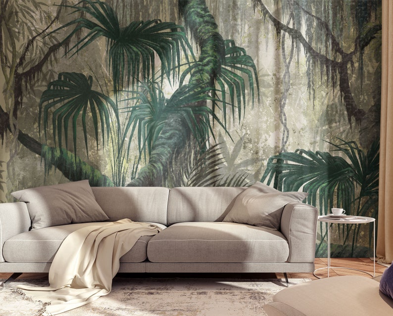 Puede incluir: Un sof&aacute; gris con una manta blanca delante de un mural de pared que representa una exuberante escena de jungla verde con palmeras y enredaderas.