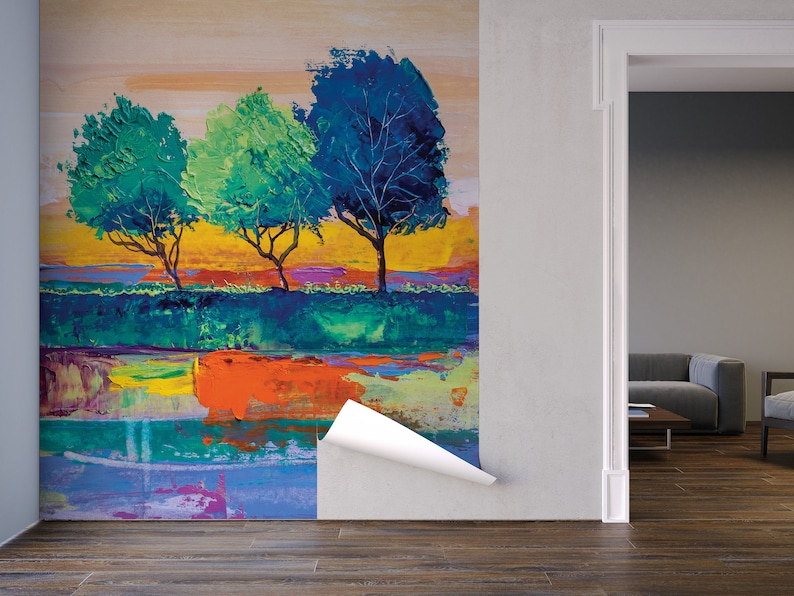 Może przedstawiać: Abstrakcyjne malowidło przedstawiające trzy drzewa z niebieskimi, zielonymi i ż&oacute;łtymi liśćmi na kolorowym tle. Obraz znajduje się na ścianie w pokoju z kanapą i stolikiem kawowym.