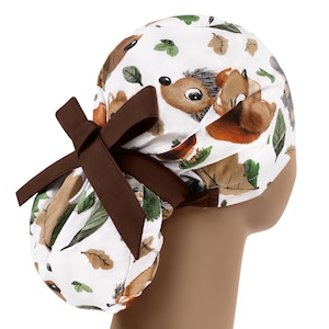 May include: A white scrub hat with a brown ribbon and a pattern of squirrels and leaves.