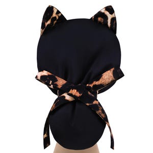 May include: Black cat ear hat with a leopard print accent on the ears and bow. The hat is made of a soft, dark fabric and features a playful design. The bow is tied at the back, adding a decorative touch.