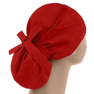 May include: A solid red scrub hat with a tie at the back. The hat is made of a soft, comfortable fabric and is designed to be worn by medical professionals.