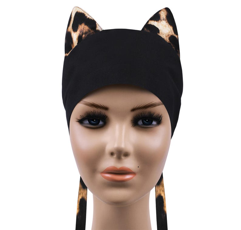 May include: Black head wrap with leopard print cat ears and matching ties. The cat ears are brown and tan. The head wrap is made of a soft material and is designed to be comfortable to wear.