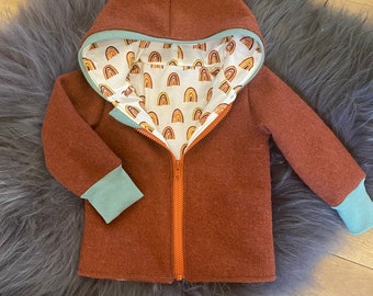 May include: A brown hooded jacket with a zipper closure and a rainbow patterned lining. The jacket has teal blue cuffs and a hood.