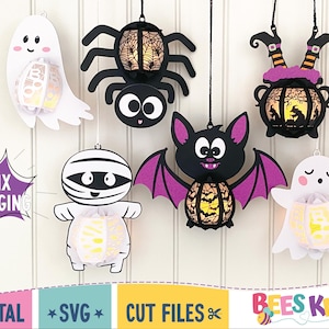 May include: Six hanging Halloween lantern decorations. The lanterns are shaped like a ghost, spider, witch's cauldron, bat, and mummy. Each lantern has a light inside and is made of paper. The lanterns are hanging from a white wall.