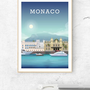 May include: A colorful illustration of the Monaco cityscape with the text "MONACO" at the top. The illustration features buildings, a mountain, a harbor, and boats.