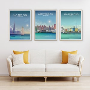 May include: Three framed city skyline posters with a white background. The posters feature illustrations of London, Amsterdam, and Waterford. Each poster has the city name and country at the top.