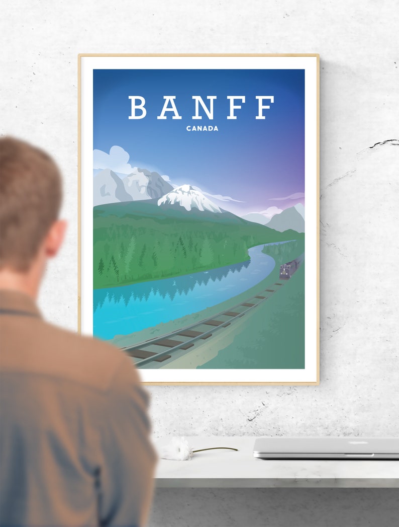 Pu&ograve; includere: Un poster vintage di viaggio con una combinazione di colori blu, viola e verde. Il poster presenta una catena montuosa, un fiume e un binario ferroviario. Il testo "BANFF CANADA" &egrave; in cima al poster.