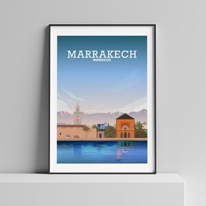 May include: A colorful illustration of the city of Marrakech, Morocco. The illustration features a pool of water reflecting the buildings and mountains in the background. The text "MARRAKECH MOROCCO" is at the top of the image.