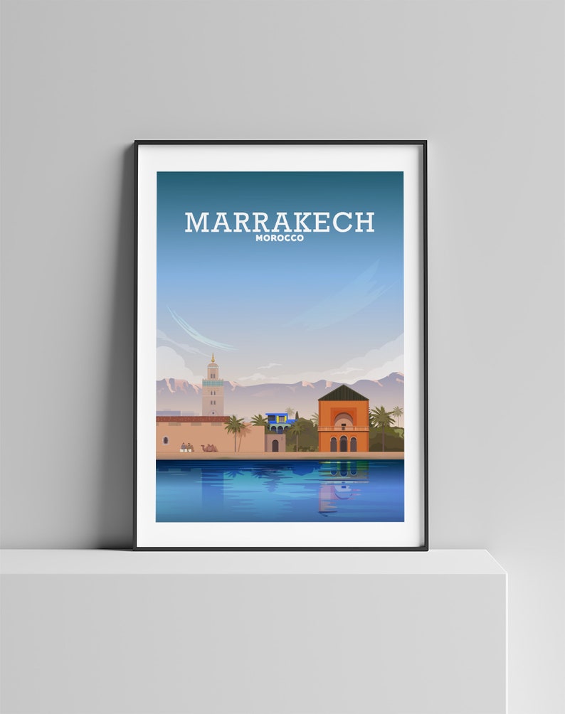 May include: A colorful illustration of the city of Marrakech, Morocco. The illustration features a pool of water reflecting the buildings and mountains in the background. The text "MARRAKECH MOROCCO" is at the top of the image.
