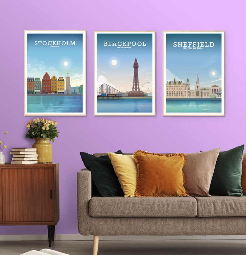 May include: Three framed city skyline posters with a light blue background and white text. The posters are hanging on a light purple wall. The posters feature the cities of Stockholm, Sweden, Blackpool, United Kingdom, and Sheffield, United Kingdom.