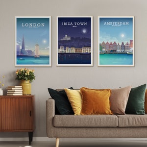 May include: Three framed travel art prints featuring cityscapes of London, Ibiza Town, and Amsterdam. The London print shows the Shard and Tower Bridge. The Ibiza Town print depicts a nighttime scene. The Amsterdam print shows colorful buildings.