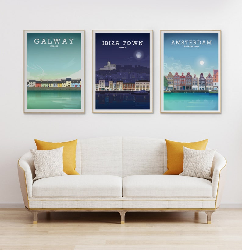 May include: Three framed travel posters featuring cityscapes. The posters display the names "Galway, Ireland", "Ibiza Town, Ibiza", and "Amsterdam, Netherlands". Each poster has a gold frame and depicts a colorful waterfront scene with a blue sky.