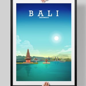May include: A framed poster with a blue and green gradient background featuring a white text overlay that reads "BALI INDONESIA". The poster depicts a temple on a body of water with a bright sun in the sky.