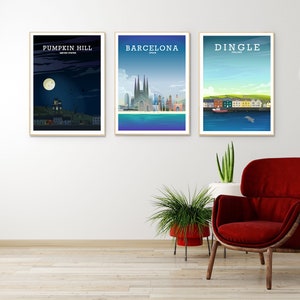 May include: Three framed city skyline posters with the names "Pumpkin Hill, United States", "Barcelona, Spain", and "Dingle, Ireland" printed on them. The posters are hanging on a white wall above a red armchair and two potted plants.
