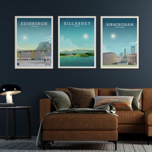 May include: Three framed city skyline posters with a brown leather couch in the foreground. The posters are of Edinburgh, Scotland, Killarney, Ireland, and Birmingham, United Kingdom.