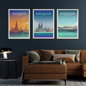 May include: Three framed city skyline posters with a brown leather couch in the foreground. The posters are titled "Bangkok, Thailand", "Barcelona, Spain", and "Portrush, Northern Ireland".