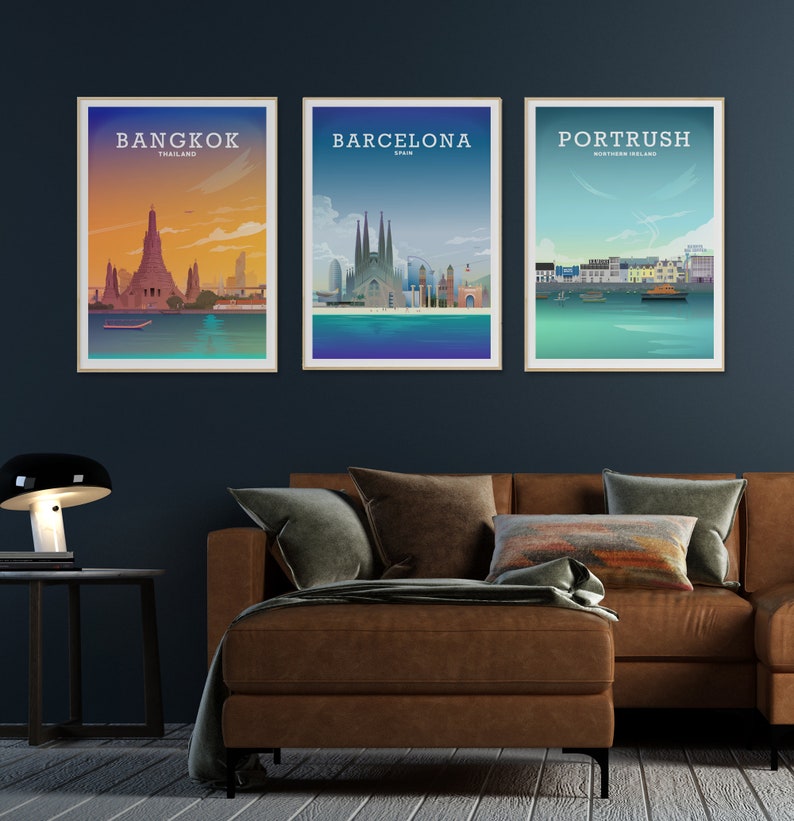 May include: Three framed city skyline posters with a brown leather couch in the foreground. The posters are titled "Bangkok, Thailand", "Barcelona, Spain", and "Portrush, Northern Ireland".