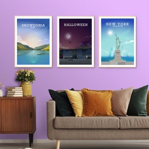 May include: Three framed posters on a purple wall. The posters are of Snowdonia, Wales, Halloween, and New York City. The posters are all in a minimalist style with a white background and black text.