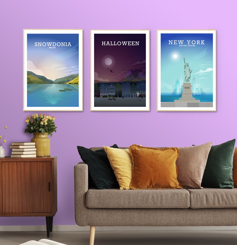 May include: Three framed posters on a purple wall. The posters are of Snowdonia, Wales, Halloween, and New York City. The posters are all in a minimalist style with a white background and black text.