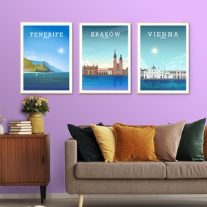 May include: Three framed posters with cityscapes. The posters are hung on a light purple wall. The posters are titled "Tenerife, Spain", "Krakow, Poland", and "Vienna, Austria".