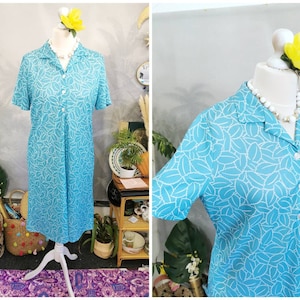 May include: A blue and white patterned dress with a collared neckline and short sleeves. The dress has a button-up front and a loose fit.