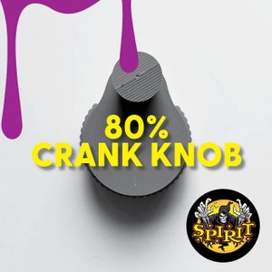 Puede incluir: Un pomo de manivela gris impreso en 3D con el texto "80% Crank Knob" en amarillo. Hay una salpicadura de pintura morada en el fondo. Una pegatina negra y amarilla con una calavera y el texto "Spirit" está en la esquina inferior derecha.