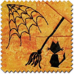 May include: A Halloween-themed fabric square featuring a black cat, broom, and spiderweb design. The cat is seated, and the broom is angled across the orange and yellow background. The spiderweb is in the upper left corner.