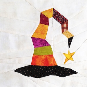 Pode incluir: Um chapéu de bruxa de patchwork colorido com uma borda preta e uma estrela amarela. O chapéu é feito de diferentes tecidos em tons de laranja, amarelo, roxo, verde e marrom.