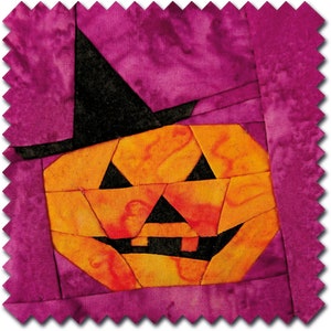 May include: A patchwork pumpkin with a black witch's hat, made from fabric scraps in shades of orange, yellow, red, and black. The pumpkin is set against a purple background.