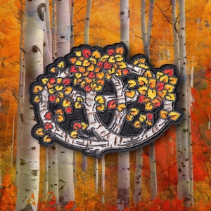 May include: An embroidered patch featuring a circular arrangement of white birch tree trunks with black markings and vibrant autumn leaves in shades of yellow, orange, and red, all set against a solid black background with a dark border.