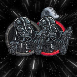 Puede incluir: Dos parches bordados negros de Darth Vader de Star Wars. Los parches son circulares y tienen un fondo rojo y gris. Un Vader señala al otro Vader.