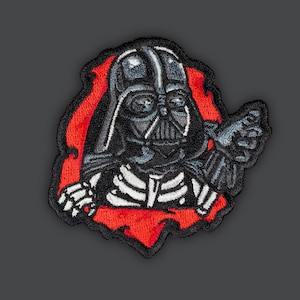 May include: A black and red embroidered patch featuring Darth Vader from Star Wars. The patch shows Darth Vader's head and shoulders, with his iconic helmet and black cape. He is shown with a menacing expression, as if he is about to strike.