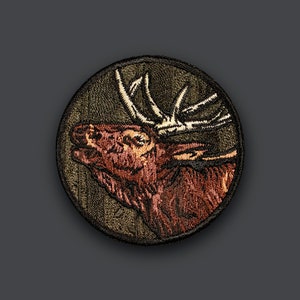May include: Embroidered patch featuring a brown and tan elk with antlers against a green background.